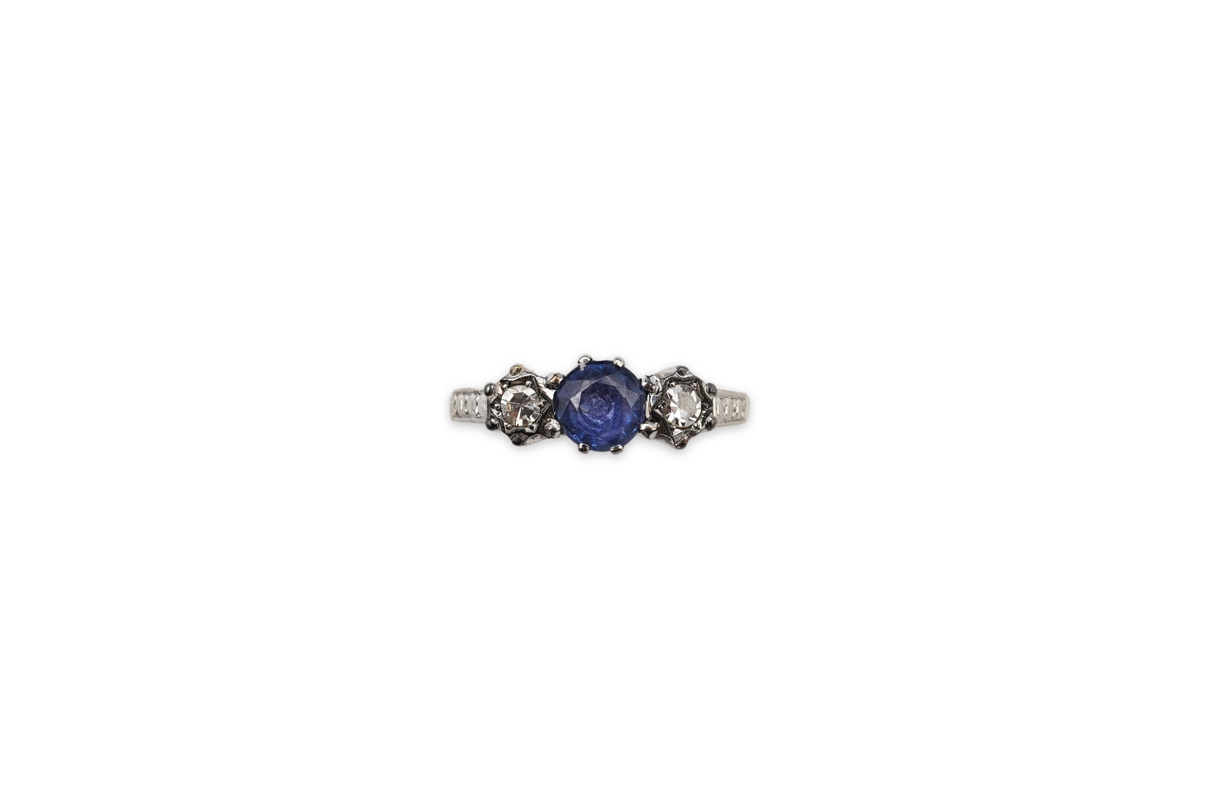 A sapphire and diamond three-stone ring, claw-set with a circular-cut sapphire measuring approximately 4.9 x 4.9 x 3.1mm, between single-cut diamonds totalling approximately 0.15 carats, mounted in gold and platinum, siz